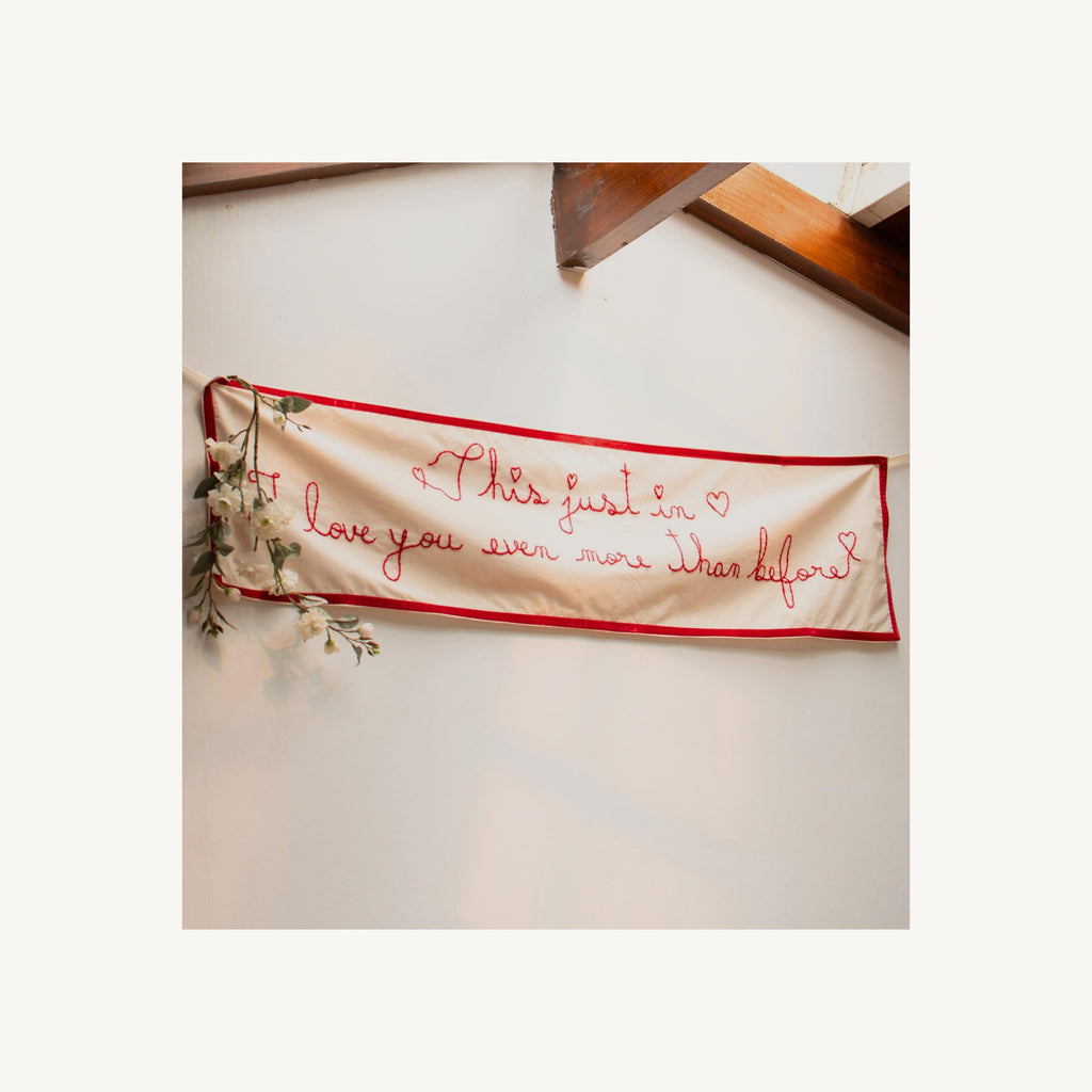 Decorative banner with embroidered text on a white background